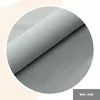 Close-up of a gray fabric material rolled up, displayed in a circular frame with a light beige background. Anteprima dell’immagine prodotto
