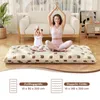 A woman and a child are meditating on a floor mattress in a living room. Produktbild-Vorschau