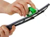 Hands using a green and white tool to clean a car windshield wiper blade. Produktbild-Vorschau