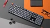 A keyboard and other desk accessories are arranged on a multi-colored surface. Produktbild-Vorschau