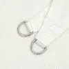 A close-up view of two D-rings attached to white fabric. Náhľad obrázku produktu