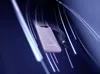 A purple power bank with a black lanyard is shown against a dark blue and purple background with streaks of light. Voir les images du produit