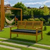 A wooden bench with an anthracite cushion sits on a green lawn in a backyard setting, with a hammock and pergola in the background. Produktbild-Vorschau