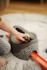 A child's hand is placing a toy tractor on a potty training seat with a race track. Produktbild-Vorschau