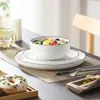 A table setting with a salad bowl, plates, cutlery, a glass of water, and a donut. Náhled obrázku produktu