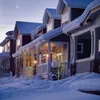 A row of houses covered in snow with decorative lights. Podgląd zdjęcia produktu