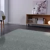A modern living room with a rug, chair, and bookshelf. Produktbild-Vorschau