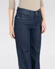 A close-up shot of a person wearing dark blue denim jeans. Produktbild-Vorschau