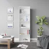 A white bookshelf filled with books and decorative items, placed next to a potted plant and a coffee table with books and decor. Produktbild-Vorschau