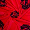 A close-up view of a red fleece blanket with a repeating pattern of the Manchester United FC logo. Náhľad obrázku produktu