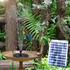 A solar-powered fountain is operating in a bird bath in a garden setting, with a hummingbird nearby. Produktbild-Vorschau