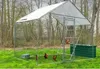 A chicken coop in a grassy outdoor setting with trees in the background. Voir les images du produit