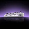 A white, futuristic-looking keyboard stand with six dark glasses on top, set against a purple gradient background and reflected on a black surface. Náhled obrázku produktu