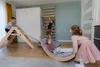 Children playing in a room with Montessori-style wooden play equipment. Produktbild-Vorschau