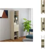 A tall, narrow bookshelf with several shelves and two drawers, placed in a room with a plant and a chair. Produktbild-Vorschau