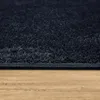 A close-up view of a navy blue rug with a textured surface, resting on a wooden floor. Produktbild-Vorschau