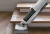A Hoover vacuum cleaner is being used to clean wooden stairs. Produktbild-Vorschau