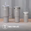 Three Stanley brand tumblers of different sizes are displayed on a wooden surface against a corrugated metal background. Text overlays "BUILT FOR LIFE" and a circular "BUILT FOR LIFE" logo are present. Produktbild-Vorschau