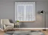 A living room scene with a chair, a small table, a window with curtains, and a floor lamp. Náhled obrázku produktu