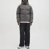 A man wearing a puffer jacket and jeans, standing against a white background. Produktbild-Vorschau