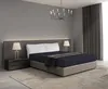 A bedroom scene with a bed, nightstand, and lamp. Produktbild-Vorschau