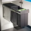 A pull-out trash can system with two bins and a small green tray, installed inside a cabinet. Produktbild-Vorschau