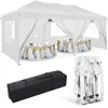 A white party tent set up with tables and chairs inside, along with a folded tent and a carrying bag. Voir les images du produit
