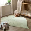 A nursery room with a crib, rug, and toys. Produktbild-Vorschau