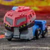 A toy robot in vehicle mode, resembling a truck, is shown from the front on a textured surface with a blurred, fiery background. Anteprima dell’immagine prodotto