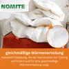 A white duvet is piled on top of an orange cushion, with a close-up inset showing the stitching detail. Náhled obrázku produktu