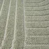 Close-up view of a textured rug with a striped pattern. Produktbild-Vorschau