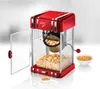A red retro-style popcorn maker with popcorn inside, a container of popped popcorn, a bowl of popcorn kernels, and a measuring scoop. Náhled obrázku produktu