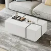 A modern white coffee table with black accents is placed on a patterned rug in a living room setting, next to a light-colored sofa. Voir les images du produit