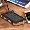 A solar power bank with two flashlights is placed on a wooden table next to a smartphone and a tablet. Voir les images du produit
