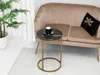 A round side table with a black marble top and gold legs sits next to a beige sofa in a living room setting. Anteprima dell’immagine prodotto