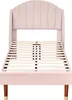 A pink upholstered bed frame with a slatted base and wooden legs. Náhľad obrázku produktu