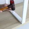 A hand is using a rubber mallet to tap a white bracket onto a light wood surface. Produktbild-Vorschau