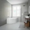 A modern, minimalist bathroom featuring a large corner bathtub, a vanity with a sink, and a window overlooking a city view. Produktbild-Vorschau