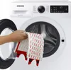 A hand is placing a mop head into a washing machine. Náhled obrázku produktu