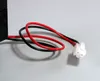 A close-up of a black battery with red and black wires connected to a white connector. Produktbild-Vorschau