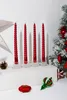 Four red spiral candles are displayed on a white surface, with Christmas decorations in the background. Náhled obrázku produktu