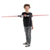 A young boy holds a double-bladed lightsaber horizontally in front of him against a white background. Produktbild-Vorschau