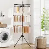 A laundry room with a washing machine and a three-tier drying rack filled with clothes. Anteprima dell’immagine prodotto