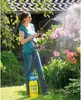 A woman is using a garden sprayer on plants in a garden. Produktbild-Vorschau