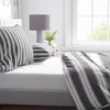 A close-up view of a bed with striped bedding. Produktbild-Vorschau