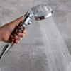 A hand holding a shower head with water spraying from it. Produktbild-Vorschau