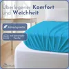 A close-up of a turquoise fitted sheet on a white mattress, with text overlays highlighting product features. Produktbild-Vorschau