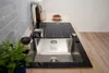 A kitchen sink with a faucet and a small bowl of strawberries on a countertop. Produktbild-Vorschau