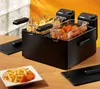 A black double deep fryer with two baskets filled with french fries and chicken nuggets, placed on a wooden table. Produktbild-Vorschau