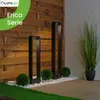 Two modern black bollard lights are placed in a garden setting with a wooden fence and greenery. Anteprima dell’immagine prodotto